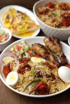 several plates of food on a table with eggs and other foods in bowls around them