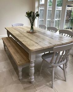 a wooden table with white chairs around it