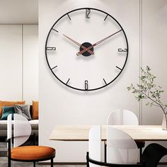 a large clock mounted to the side of a wall in a living room next to a dining table