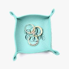 two monogrammed rings in a turquoise tray