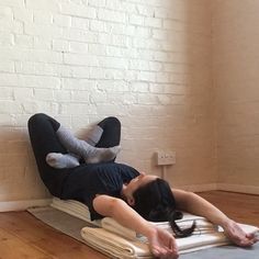 a woman laying on top of a yoga mat