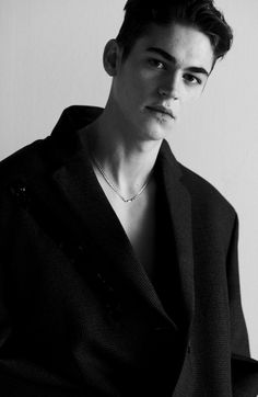 black and white photograph of a young man in a blazer looking at the camera