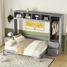 a bed sitting under a book shelf next to a wall mounted cabinet with clothes on it