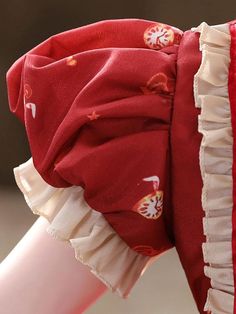 a close up view of a red dress with ruffles on it's sleeves