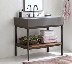 a bathroom sink sitting under a mirror next to a shelf with towels and plants on it