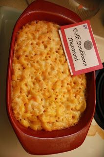 a red casserole dish with macaroni and cheese in it next to a stove