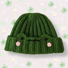 a green knitted hat with two buttons on the front and one button at the back