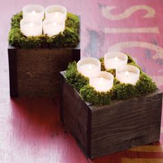 two wooden boxes filled with candles on top of a table