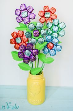 a vase filled with assorted chocolates on top of a table