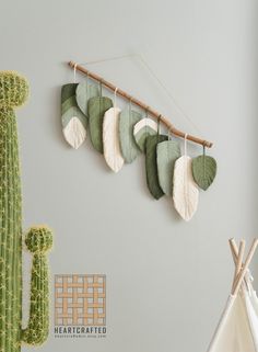 a cactus and some leaves hanging on a wall next to a teepeel plant