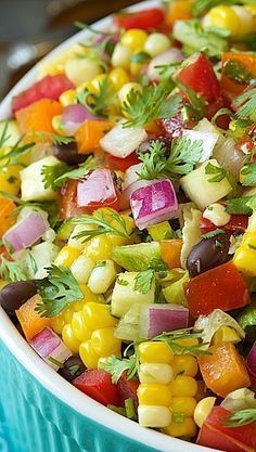 a colorful salad is in a bowl with fresh herbs on the top, and garnished with cilantro