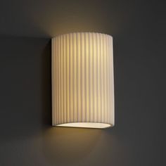 a white wall light mounted on the side of a wall next to a gray wall