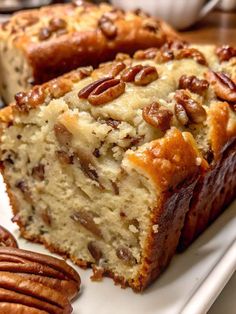 two slices of pecan bread on a white plate with pecans around the edges