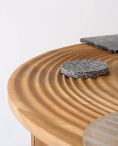 two pieces of wood sitting on top of a wooden table next to another piece of stone