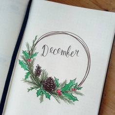 an open notebook with a christmas wreath and pine cones on the cover that says december