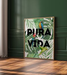 a framed poster with the words pura vida on it in front of a green wall