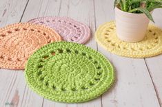 four crocheted coasters with a potted plant in the middle