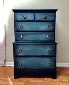 a blue dresser sitting on top of a hard wood floor