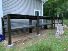 an outside view of a house with some benches and trash cans on the ground in front of it