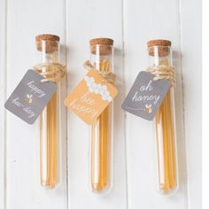 three small bottles filled with honey sitting next to each other