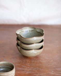 four small bowls sitting on top of a wooden table