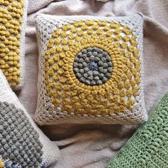 two crocheted pillows sitting next to each other