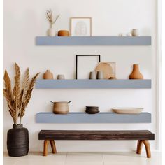 the shelves are filled with bowls, plates and vases on top of each shelf