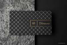 a black and white business card with gold foil on the front, next to a gray background