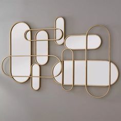 four mirrors are arranged on the wall, one is shaped like an oval and two are shaped as rectangles