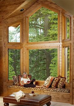 a woman sitting on a window sill in front of a large window with lots of windows