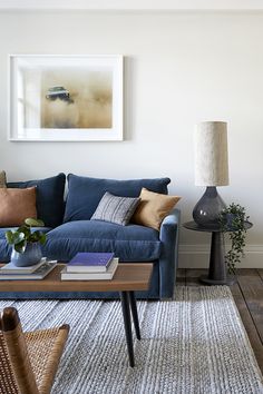 a living room filled with furniture and a painting on the wall above it's coffee table