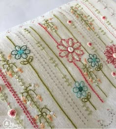 a close up of a piece of fabric with flowers on it and beads in the middle