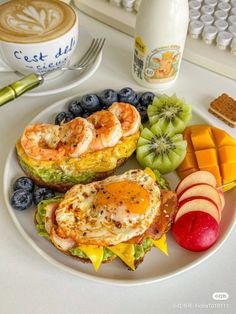 a white plate topped with sandwiches and fruit next to a cup of coffee