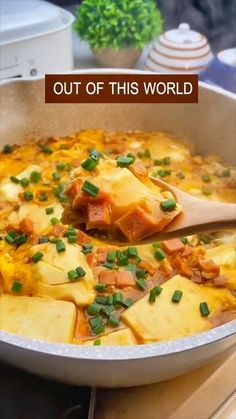 a casserole dish with potatoes and green onions in it, topped with cheese