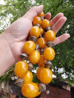 "Brilliant egg yolk yellow phenolic resin beads with metal spacers on this antique necklace, possibly Ethiopian. This type of resin bead, sometimes called African amber, was made of the same or similar materials as catalin (the jewelry form of bakelite). Each bead is approximately .75\" wide x .9\" long. I don't know what the metal spacers beads are made of. As found, necklace cord is quite stretched out. Total weight is approximately 200g (7 ounces), length is approximately 32\", 21 resin beads Vintage Amber Resin Jewelry, Handmade Round Bakelite Jewelry, Vintage Yellow Resin Jewelry, Vintage Polished Yellow Beads Jewelry, Vintage Orange Wooden Beads, Vintage Yellow Jewelry With Polished Beads, Vintage Yellow Jewelry With Large Beads, Vintage Amber Oval Beads, Vintage Orange Oval Beads Jewelry