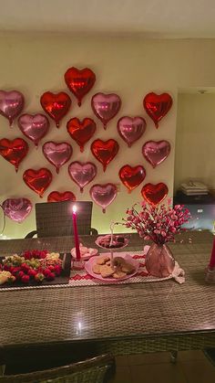 a table topped with lots of heart shaped balloons