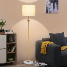 a living room with a gray couch and yellow throw blanket on the floor next to a lamp