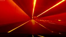 the inside of a car driving through a tunnel with red light coming from it's windows