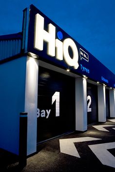 an image of a store front that is lit up at night with blue sky in the background