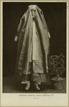 an old black and white photo of a woman wrapped in a cloth over her head