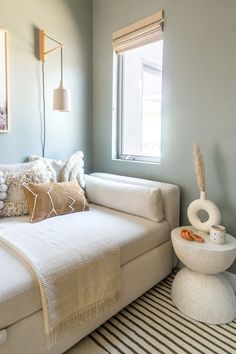 a white couch sitting next to a window in a living room