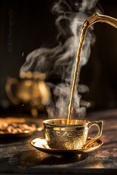 steaming tea being poured into a cup