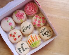 a box filled with decorated cookies on top of a wooden table