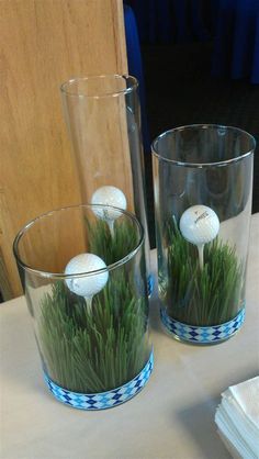 two vases with grass and golf balls in them