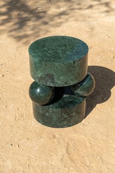 a green bench sitting on top of a dirt field