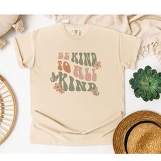 This motivational tee in earth tones gives off cute retro vibes, with an uplifting message to be kind to all kind. The relaxed fit tee is perfect for gifting during birthdays, holidays, or as a reminder to spread kindness. Product features - Available in multiple sizes from S to 4XL - Double-needle stitching for durability - Tubular knit construction without side seams - Garment-dyed fabric for soft color and texture - Made with 100% ring-spun US cotton for long-lasting comfort Care instructions Unisex Retro T-shirt With Text Print, Be Kind To Earth Shirt, Eco-friendly Cotton Graphic T-shirt, Cotton Hippie T-shirt With Screen Print, Everyday Coffee-colored T-shirt With Text Print, Uplifting Messages, Retro Vibe, Earth Tones, Soft Colors