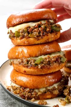 a stack of hamburgers sitting on top of a white plate