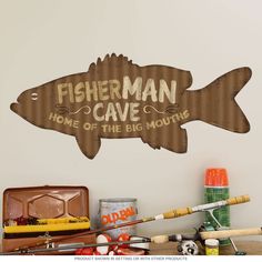 a sign that says fisherman cave on the side of a wall next to fishing gear