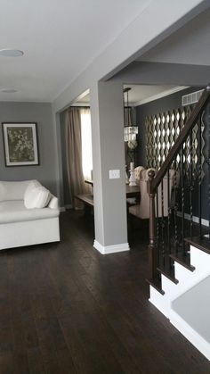 a living room filled with furniture and a staircase leading up to the second story bedroom