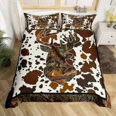 a bed covered in brown and white sheets with a deer's head on it